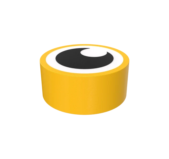 Kulatý žlutý objekt s plochou horní částí, na níž je zobrazena černobílá grafika oka v kresleném stylu, připomínající googly eye. Pozadí je hladké a obrázek je dobře osvětlený.